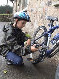 Harry oils his chain with Michael's cycle oil outside Bellever Youth Hostel
