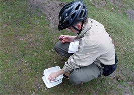 Gage examines his Dartmoor letterbox near the River Avon on the path from Shipley Bridge to the Avon Dam