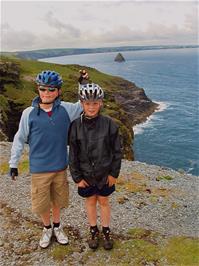 Olly and Ashley outside Tintagel Youth Hostel, with Gull Rock in the distance