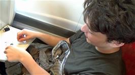 Lawrence prepares to sew a button onto his shorts, on the 12:30 Virgin train from London Euston to Lancaster