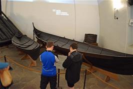 Jude and Dillan study a burial chamber and small boats taken from the Gokstad burial mound