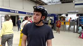 Dillan checks the train departures board at Inverness station